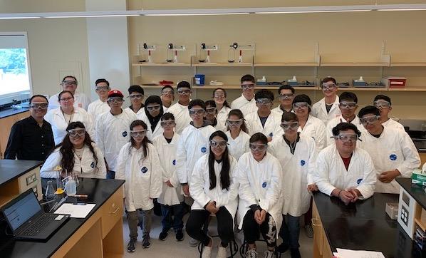 Juntos campers taking group photo in lab coats in lab