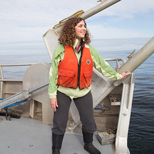 Sarah Henkel sitting on boat overlooking ocean