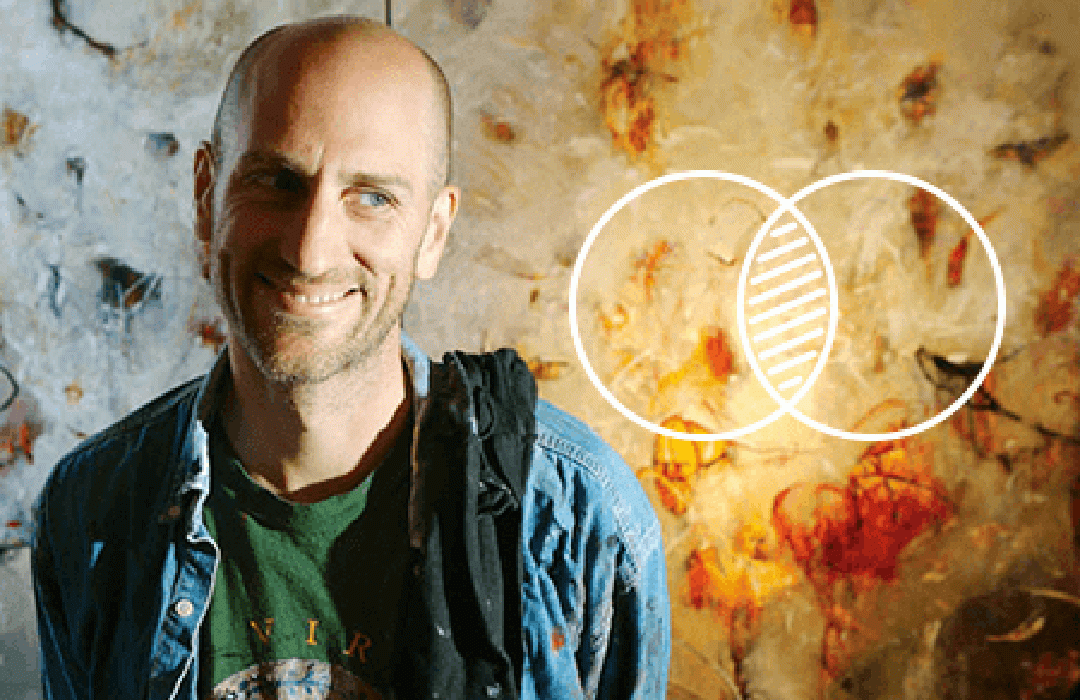 Michael Schultheis standing in front of his paintings with intersecting circle icon