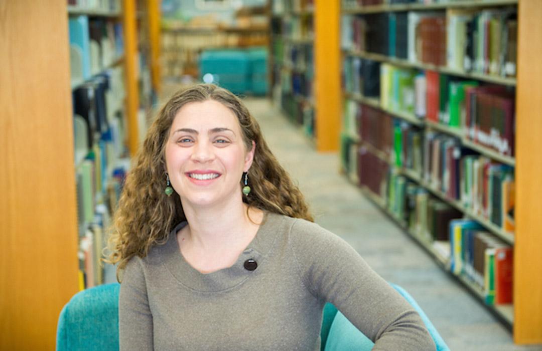 Sarah Henkel sitting in front of book shelves