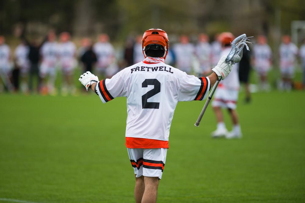The back of a lacrosse player wearing a jersey with the number 2. 
