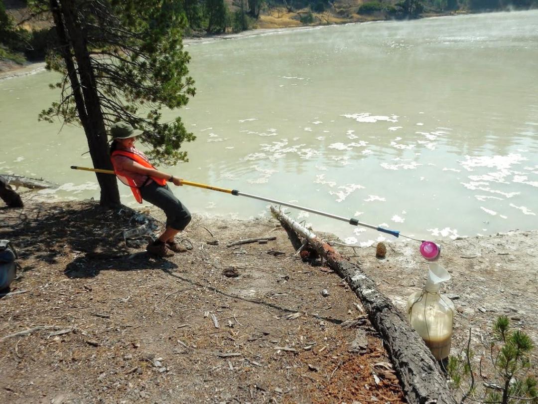 Alyssa Pratt holding a fishing rod near a river.