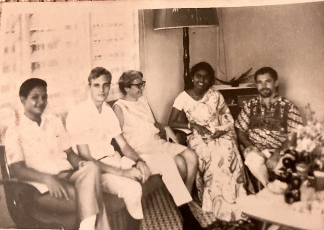 Five people sit on a couch in a black and white photo in Kuala Lumpur, Malaysia.