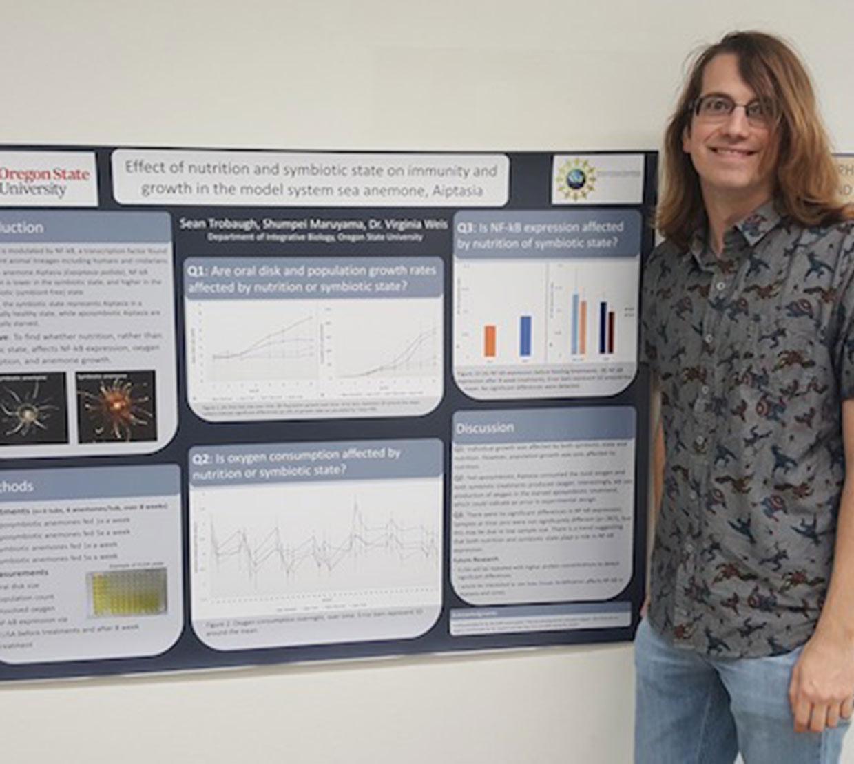 Sean Trobaugh in front of research poster