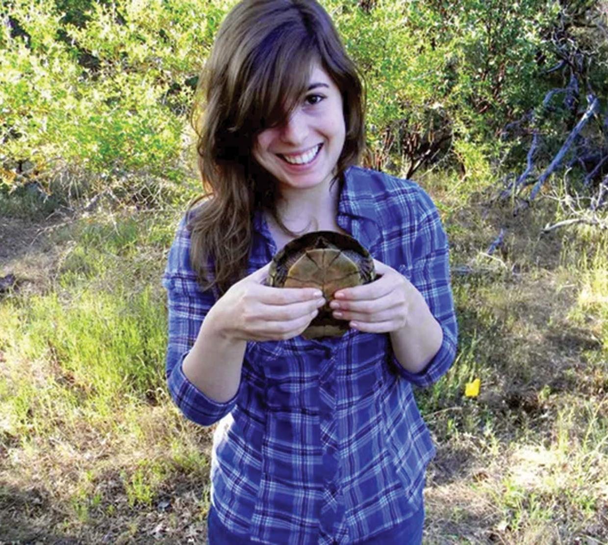 Natalie Hambalek holding tortoise in field