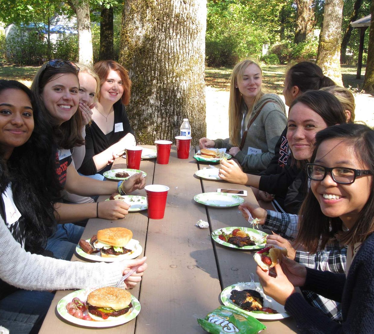 students sitting around picnic table eating lunch