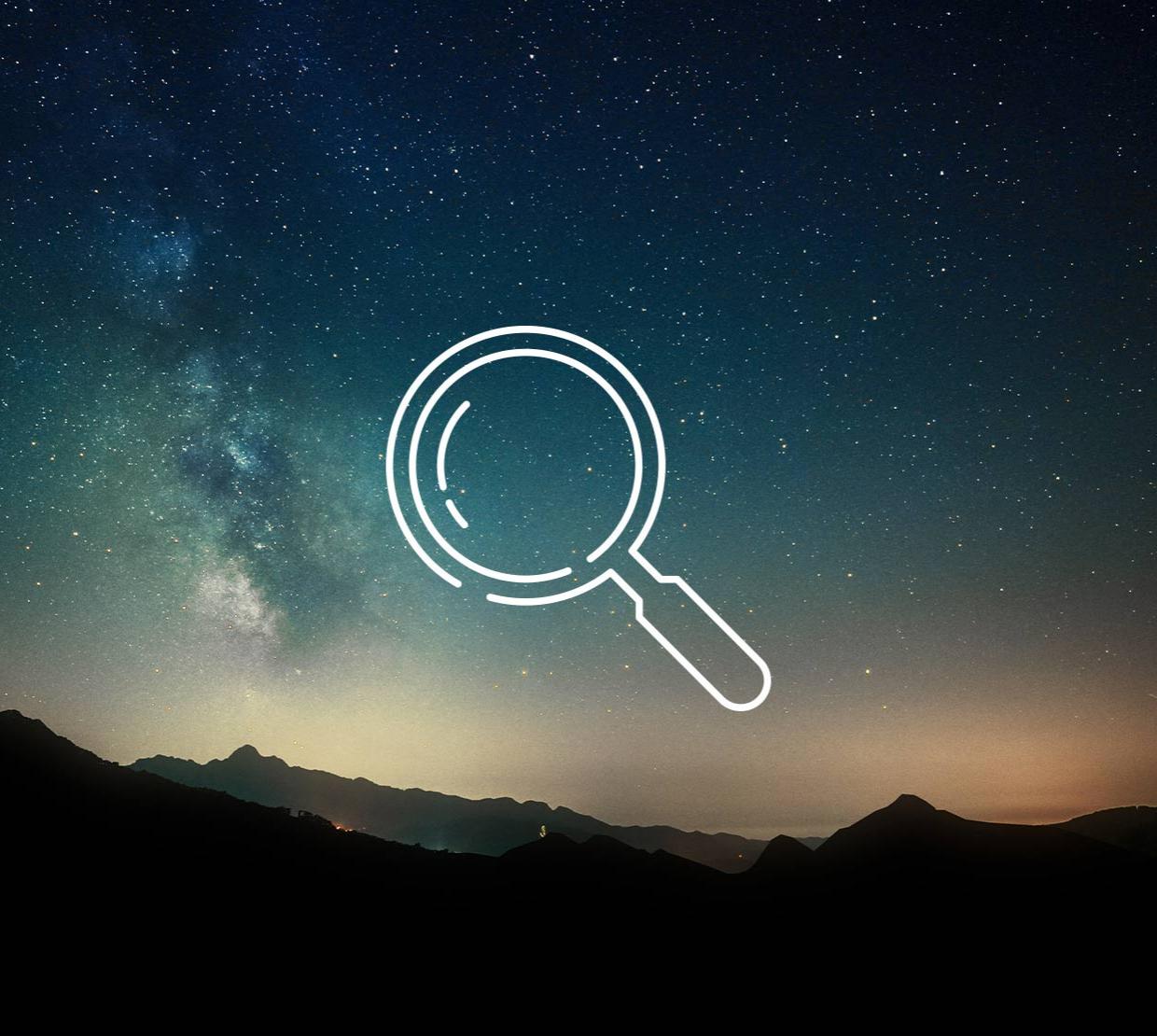 magnifying glass icon above image of mountain ridge at night