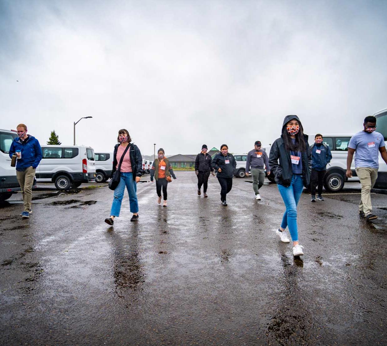 TRACE field staff walking along parking lot in Newport, Oregon on a cloudy and rainy day.
