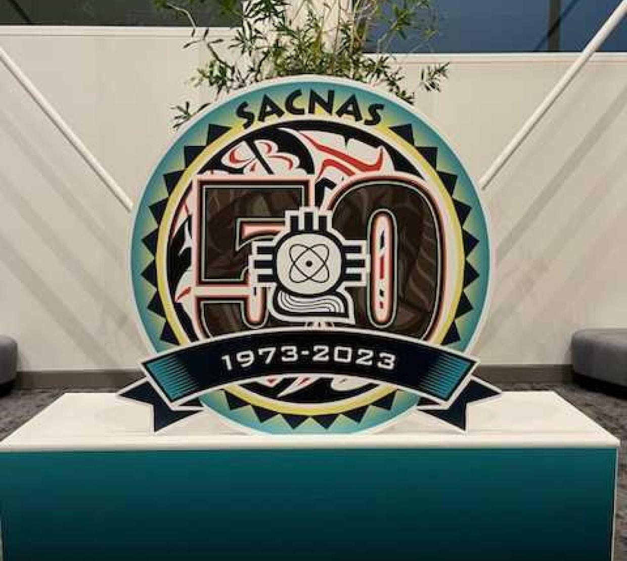 A turquoise podium with a SACNAS figure showing the years 1973 to 2023.