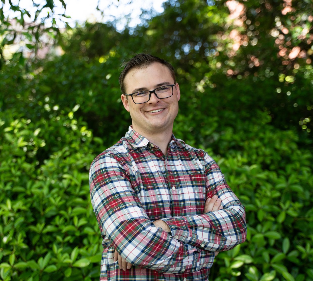 A man in a plaid shirt poses for a photo.