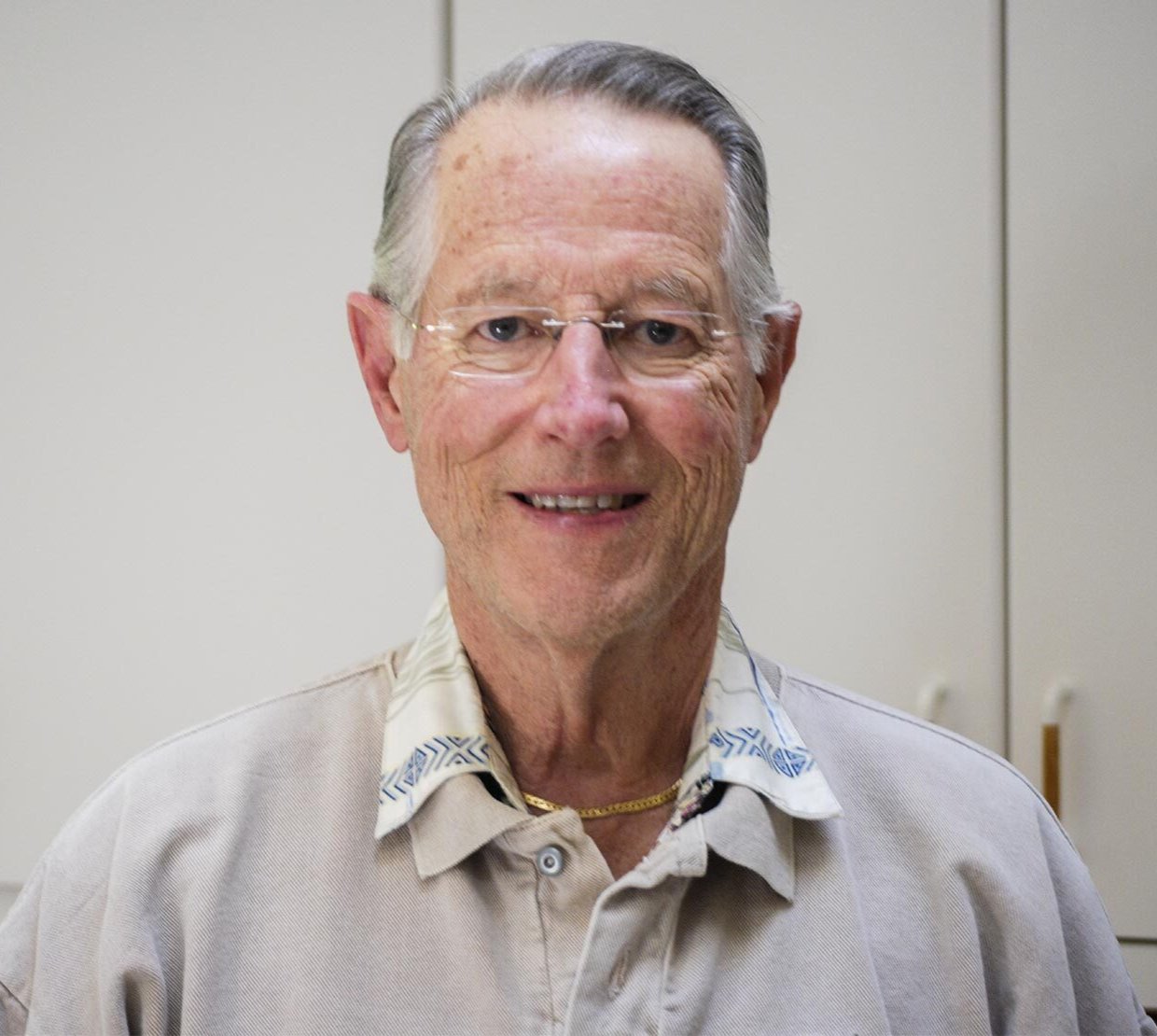 A man in grey shirt poses for photo.