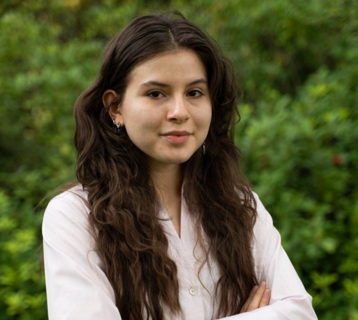 A woman in a pink shirt poses for a headshot.