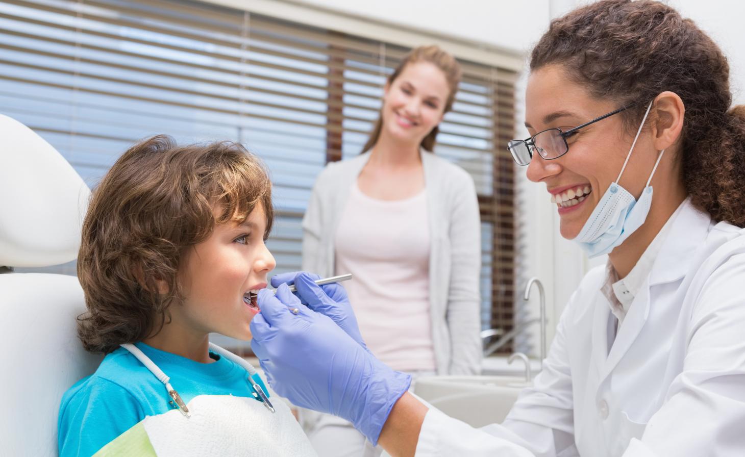 A young dentist working with a child