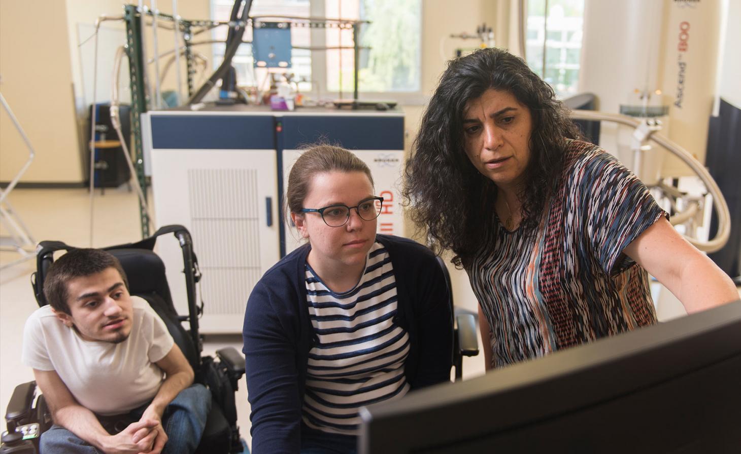 Elisar Barbar analyzing lab results with graduate students in her lab.