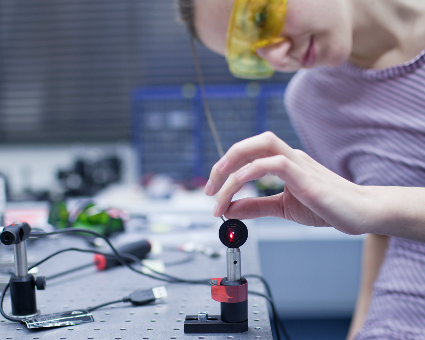 Student repairing laser equipment in lab