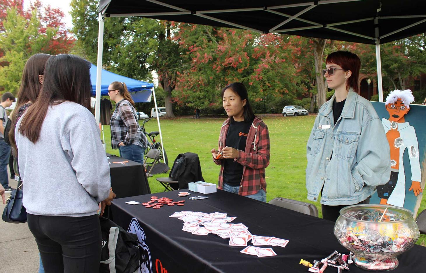 Peer advisors talking with students at College of Science booth in Memorial Union quad.