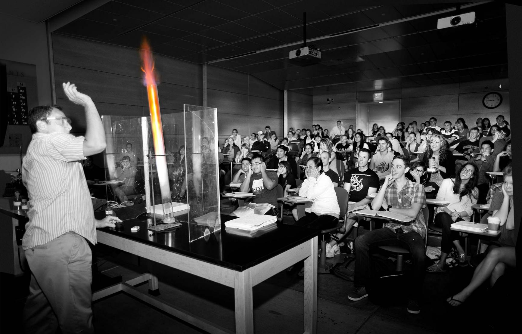 black and white photo of Richard Nafshun lighting fire in lecture demo