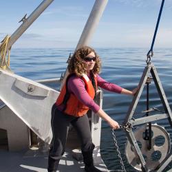 Sarah Henkel on a boat working with marine research machinery