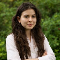 A woman in a pink shirt poses for a headshot.