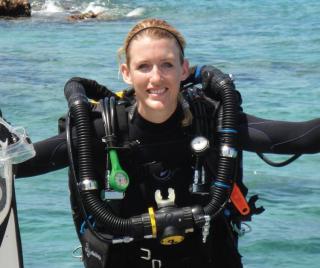 Megan Cook in scuba gear climbing into boat