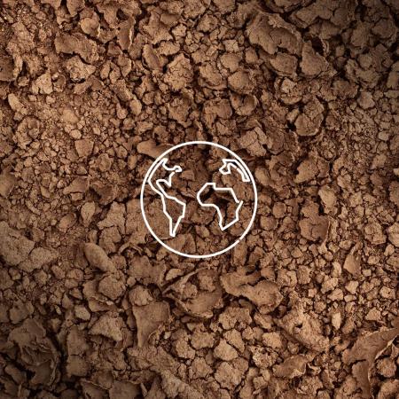 A background of brown soil with a white outline of earth. 