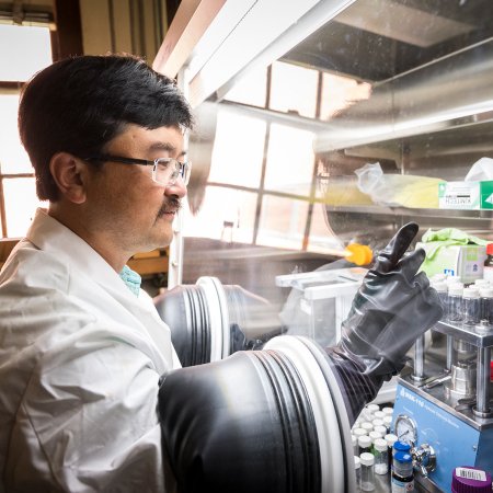 David Ji works in a chemistry lab wearing gloves in a tank.