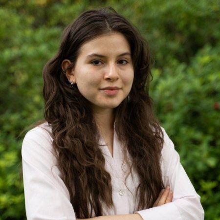 A woman in a pink shirt poses for a headshot.