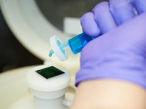 scientist in purple gloves transferring samples