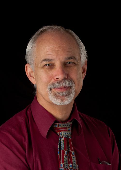 Neal Slesynski in front of black backdrop