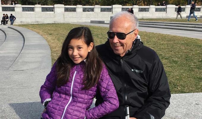 John Gardner with grand daughter sitting in a park