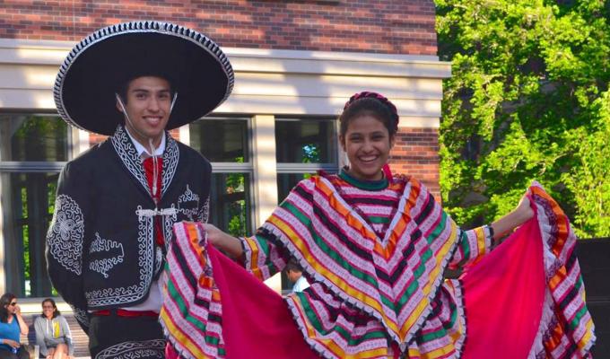 two students dressed in traditional Mexican festival garments in the SEC awning