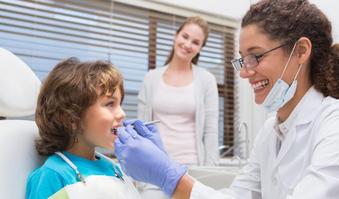 A young dentist working with a child