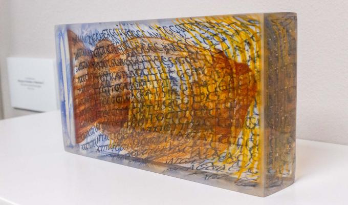 Artwork, a piece of glass with screen printing of a DNA sequence inside of it.