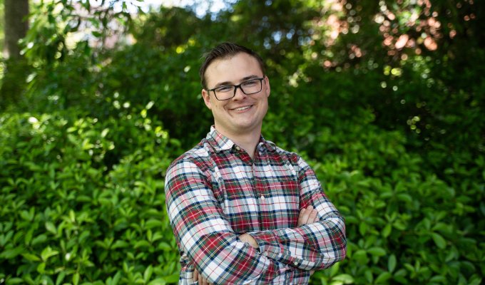 A man in a plaid shirt poses for a photo.