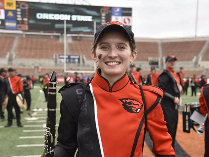 McKenzie Meyer standing on Reser Stadium field with band uniform