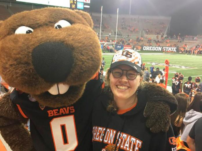 Renee Doran hugging Benny the Beaver at OSU football game