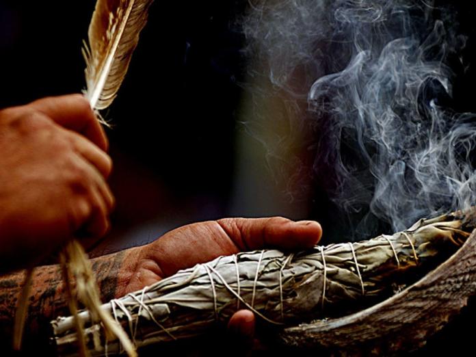 Hands performing a smudging ceremony.