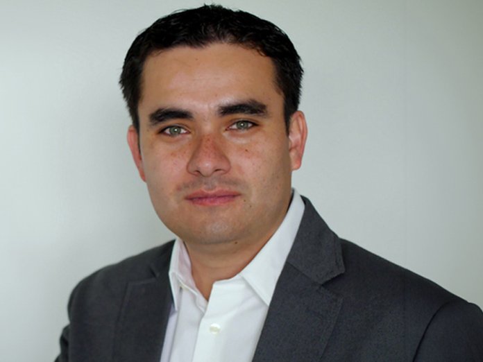 Headshot of a man in a blazer and button up 