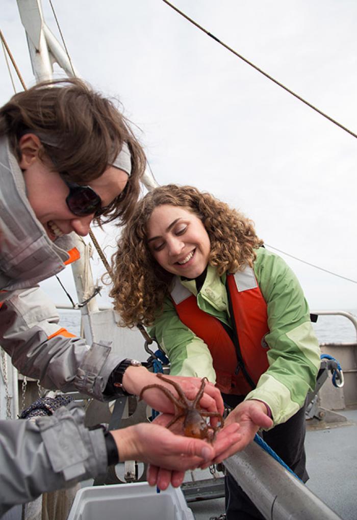 Sarah Henkel and Lenaig Hemery holding small octopus on boat