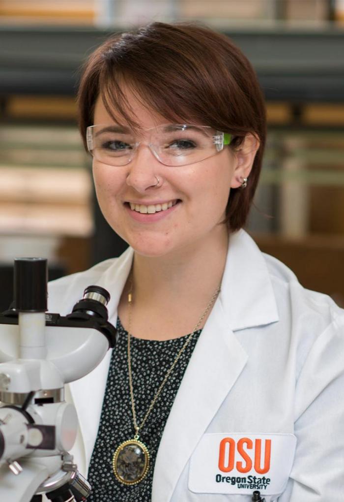 Microbiology Ph.D. student Grace Deitzler with microscope