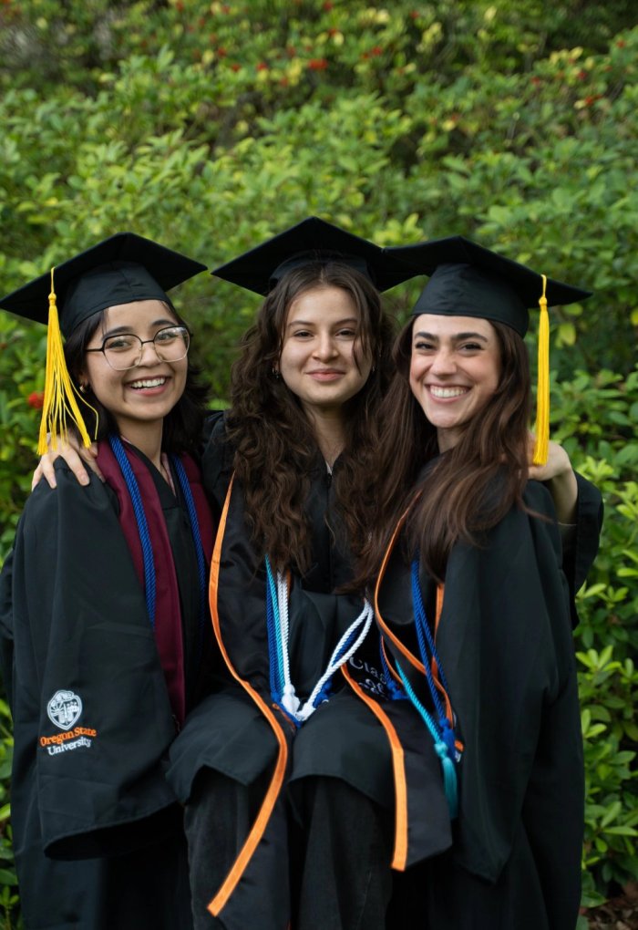 Three women in graduation regalia.