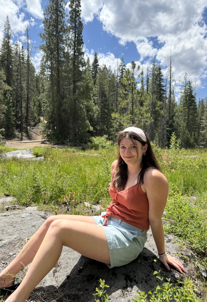 A woman poses for a photo while hiking.