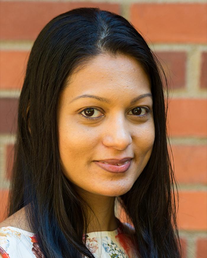 Sulochana Wasala standing in front of a brick wall.