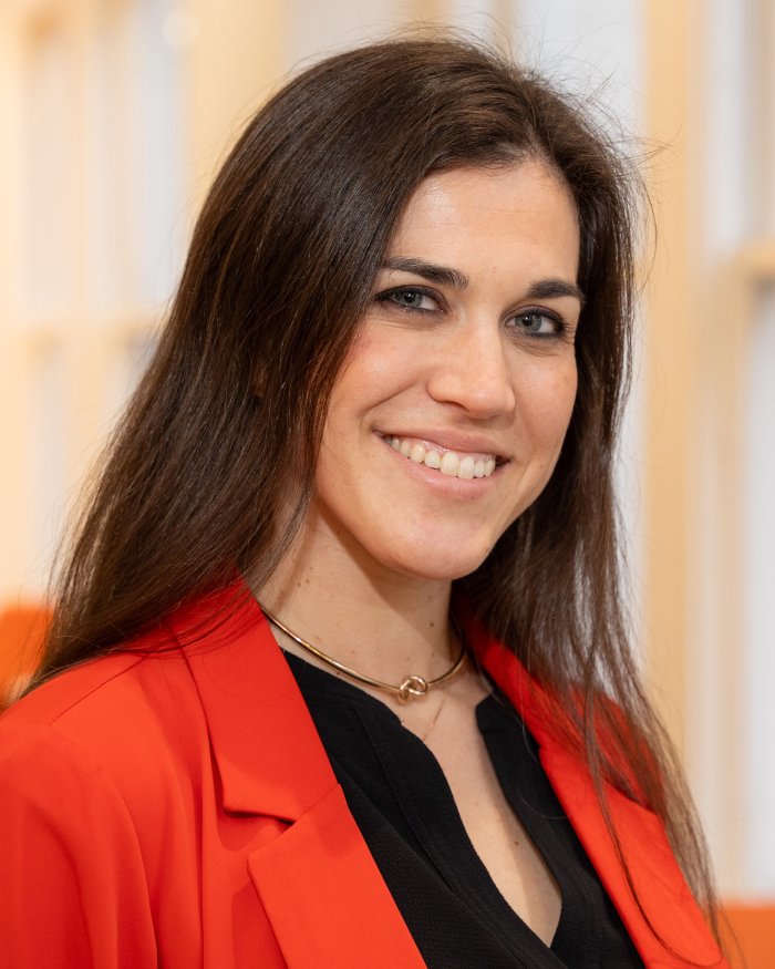 A smiling woman in a brightly colored blazer