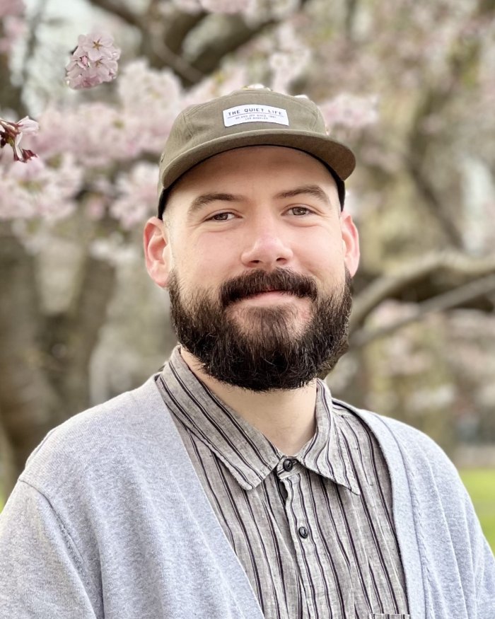 Nick Pokorzynski standing in front of a flowering tree.