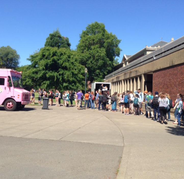 students lined up towards pink delivery truck