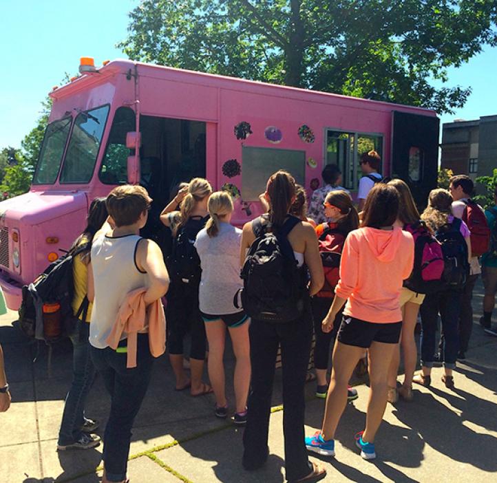 students lined up towards pink delivery truck