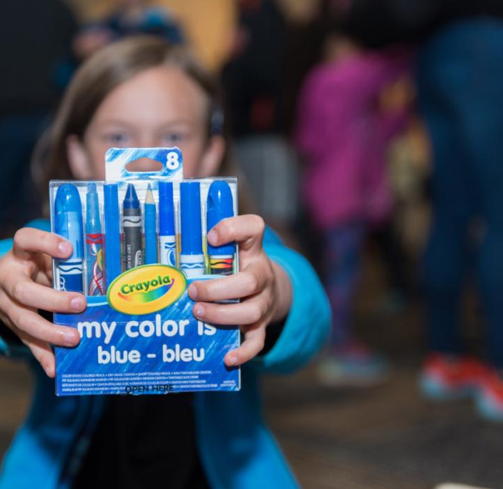 child holding blue Crayola package