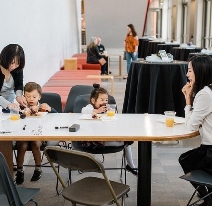 toddlers enjoying food with mothers at table