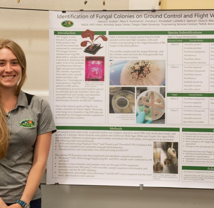 Jessica Scotten standing next to her research poster